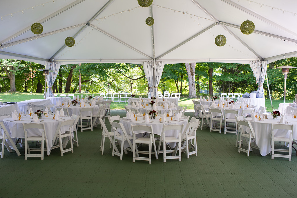 round tables set for wedding reception under tent
