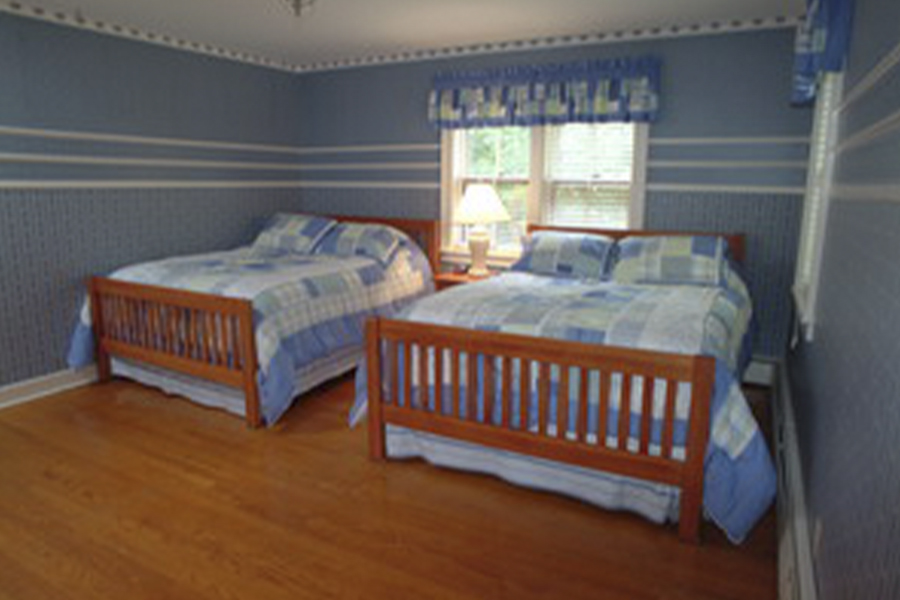 Two beds with blue quilts in The Chalet House