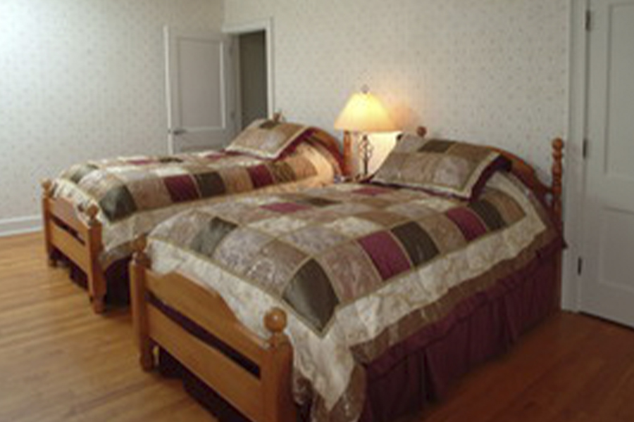 Two beds with quilts in The Chalet House