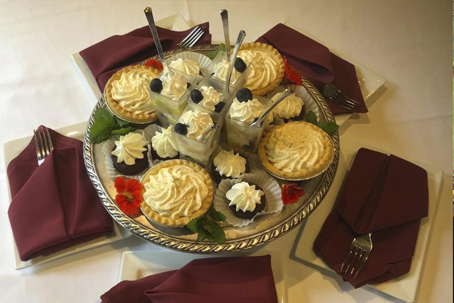 variety of desserts on tray surrounded by forks