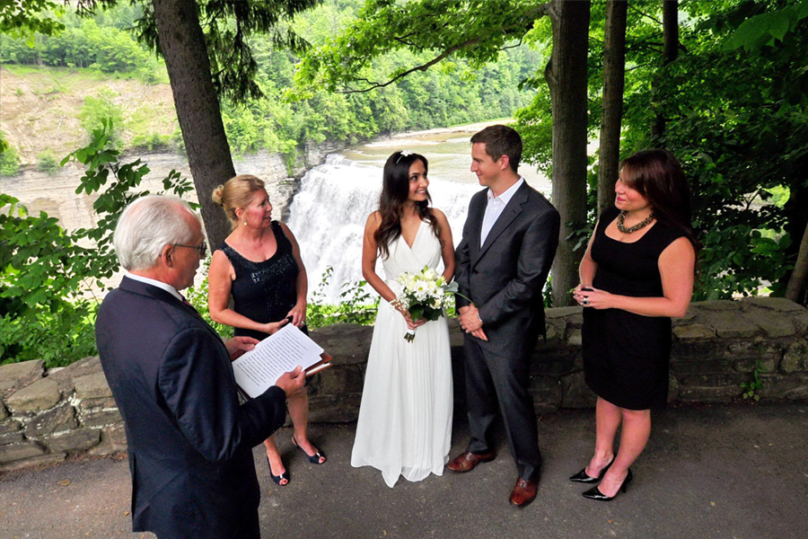 couple marries with witnesses in front of waterfall