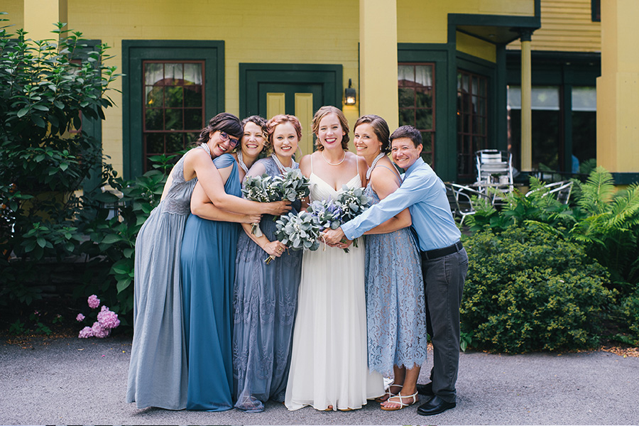 bride and wedding party pose with bouquets in front of Inn